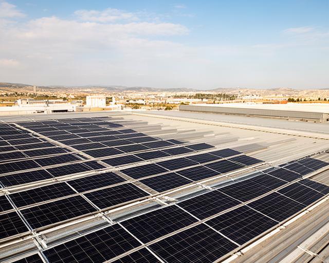 Paneles solares fotovoltaicos instalados sobre una cubierta industrial cerca de Valencia, con cielo despejado