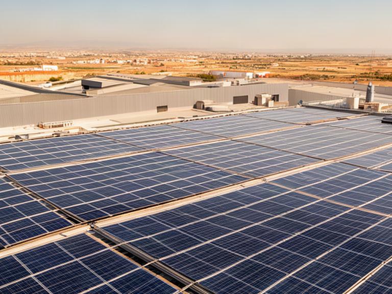 Paneles solares fotovoltaicos sobre la cubierta de una nave industrial en Valencia